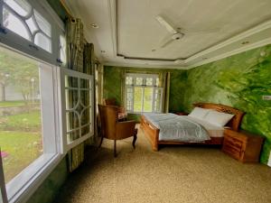 锡卡都Taaj Residence Skardu的卧室配有床、椅子和窗户。
