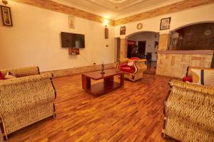 坎帕拉The Forest House - Kawuku-Bunga的客厅配有椅子、桌子和电视
