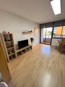 维拉德塞斯Ca La Noa 2的客厅铺有木地板,配有平面电视。