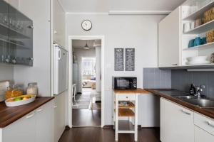 坦佩雷Tilava ydinkeskustakaksio ilmaisella autopaikalla的厨房配有白色橱柜和台面