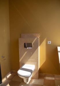 格但斯克Open Doors Villa的浴室设有黄色墙壁上的白色卫生间