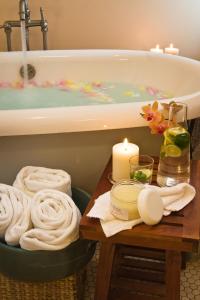阿什兰阿什兰温泉酒店 的带浴缸的浴室以及带毛巾的桌子。