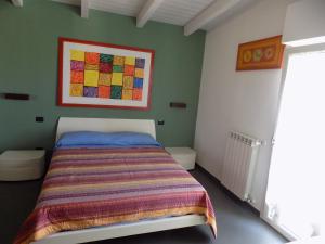 巴里Attico Stazione - Montello 16的卧室配有一张床,墙上挂有绘画作品