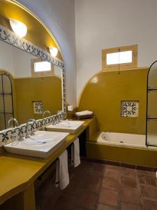 圣卡洛斯La Vaca Tranquila的浴室配有两个盥洗盆和浴缸。