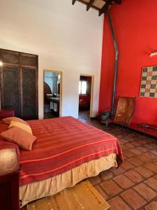 圣卡洛斯La Vaca Tranquila的一间卧室设有一张带红色墙壁的大床