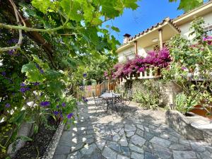 希洪La Casa de la Buganvilla的一座种有紫色花卉和桌椅的花园