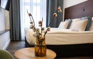 托伦托伦索瓦公寓式酒店的卧室里一个花瓶,桌子上放着鲜花