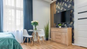 科沃布热格Apartament Turkus 4 A - Holiday City的一间卧室配有电视和桌椅