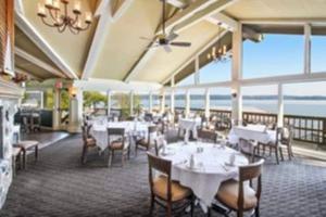 日内瓦湖Lake Geneva's resort amenities的一间带桌椅的海景餐厅