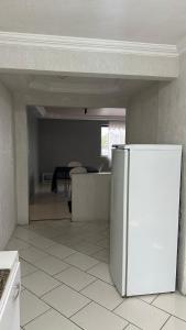 蓬塔格罗萨Apartamentos na região Central Cobertura e 2 quartos的厨房配有白色冰箱和桌子