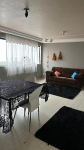 蓬塔格罗萨Apartamentos na região Central Cobertura e 2 quartos的客厅配有桌子和沙发