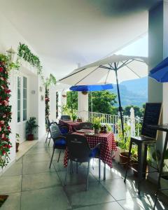 马拉加El nido del Chorro的庭院配有桌椅和遮阳伞。