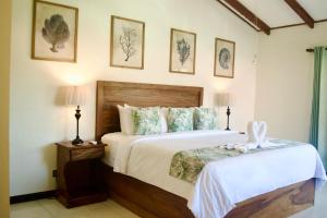 曼努埃尔安东尼奥Hotel Playa Espadilla & Gardens的一间卧室配有一张大床和两盏灯。