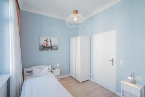 宾茨Villa Baltik的一间拥有蓝色墙壁的卧室、一张床和一个吊灯