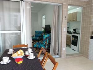 伊塔尼亚恩Lindo Apartamento na Praia do Sonho的一间带桌椅的用餐室和一间厨房
