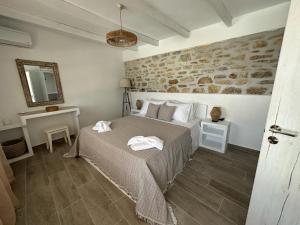 利普西岛Nature & Sea Lipsi的一间卧室设有一张床和石墙