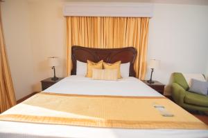奇南德加罗斯波塔利斯酒店的一间卧室配有一张床和一把绿色椅子