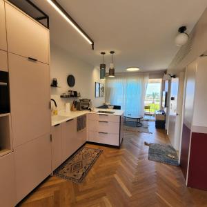 凯撒利亚lasuita- exclusive suites cesarea- sea view suite的厨房铺有木地板,配有白色橱柜。
