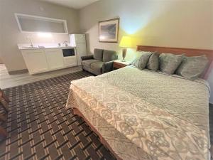 爱达荷福尔斯FairBridge Extended Stay, a Kitchenette Hotel的配有一张床和一把椅子的酒店客房