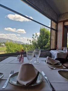 贝塞里尔德拉谢拉Hotel Rural Las Gacelas的一张桌子,上面有白色的桌布,玻璃杯和窗户