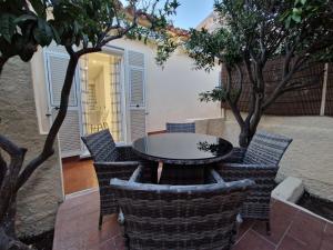 马达莱纳La Maddalena Holiday Home的庭院配有桌椅和树木