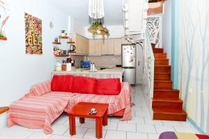 卡拉马塔CuckoosNest的一间带红色沙发的客厅和一间厨房
