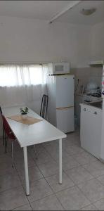 包道乔尼托毛伊Badacsonyi Csobbanás privát bérlemény的厨房配有白色桌子和白色冰箱。