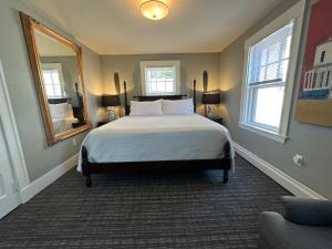 普罗温斯敦Gifford House的一间卧室配有一张床和镜子