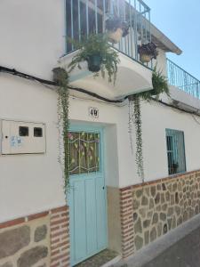 佩德罗－贝尔纳多La casa de tío Vidal的拥有蓝色门和阳台的房子