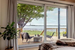 纽约Collective Governors Island的一间卧室设有大玻璃门,享有水景