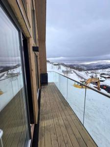 松达尔Rindabotn Fjelltun的地面上积雪的建筑的阳台