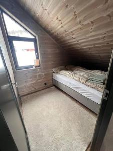 松达尔Rindabotn Fjelltun的一间小卧室,配有床和窗户