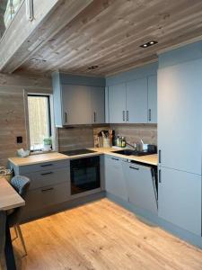 松达尔Rindabotn Fjelltun的厨房配有白色橱柜和木制天花板