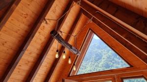 斯库台Bungaja Chalets的吊灯挂在小木屋的天花板上