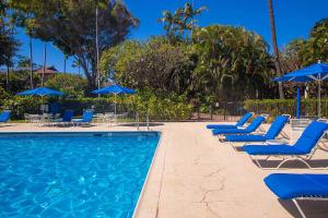 维雷亚Makena Surf- CoralTree Residence Collection的一个带蓝色躺椅和遮阳伞的游泳池