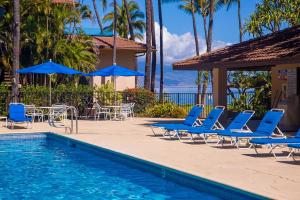 维雷亚Makena Surf- CoralTree Residence Collection的毗邻度假酒店的带椅子和遮阳伞的游泳池