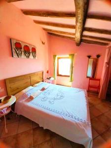 马萨The Four Angels的卧室配有一张大床,位于带粉红色墙壁的房间