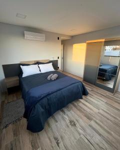圣若阿金Apartamento La Vie的一间卧室设有一张大床和一个大镜子