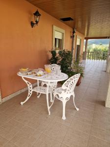 洛萨Recanto da Serra - Alojamento Local的庭院里的白色桌椅
