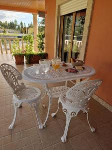 洛萨Recanto da Serra - Alojamento Local的庭院里的白色桌椅