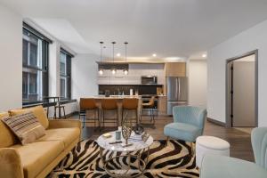 芝加哥Fully Furnished Apt Near Millenium Park- 29的客厅以及带沙发和桌子的厨房。
