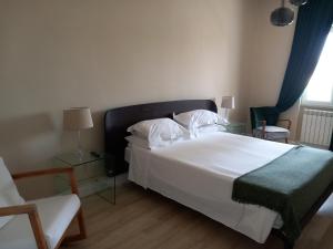 塔兰托Aparthotel Masseria Villa Marchesi的卧室配有一张白色大床和一把椅子