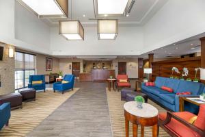 卡尔斯巴德卡尔斯巴德舒适套房酒店的医院的大厅,里面摆放着蓝色的长沙发和椅子