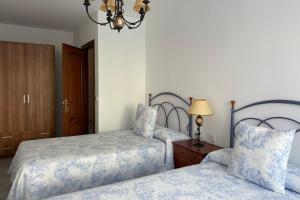 菲尼斯特雷SanMar的一间卧室配有两张床和吊灯。