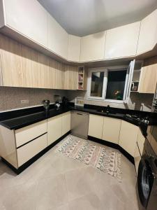 索维拉Appartement jade的厨房配有白色橱柜和地板上的地毯