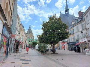 德勒LE CHIC ETHNIC DREUX 52m2 - 50 MIN DE PARIS - PARKING GRATUIT的沿着城市街道走的人,有建筑