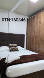 圣罗莎德卡瓦尔Apartamento Family 3的一间卧室配有一张大床和木制床头板