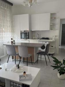 佩罗Pash apartment的厨房配有白色橱柜和桌椅