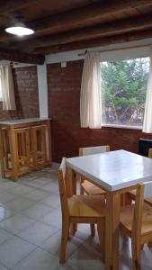 埃斯克尔Cabaña Rayen的一间带桌椅和窗户的用餐室