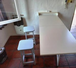 戈多伊克鲁斯Departamento 1º P, 2 personas, WIFI, confortable, mucha luz natural的厨房里两个凳子坐在白色柜台旁边